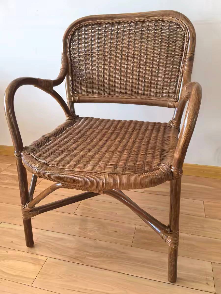 Chaise fauteuil en rotin foncé, sans coussin, vue de face